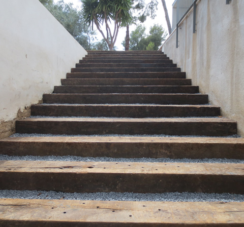 .Construcción de escaleras con traviesas y piedra decorativa.